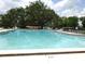 Community pool surrounded by trees and lounge chairs for relaxing enjoyment at 672 Post Oak Cir # 106, Altamonte Springs, FL 32701