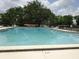 Community pool surrounded by trees and lounge chairs for relaxing enjoyment at 672 Post Oak Cir # 106, Altamonte Springs, FL 32701