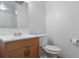 Bathroom featuring a wooden vanity, toilet, mirror and light fixture with tiled walls at 891 N Wayman St, Longwood, FL 32750