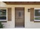Inviting front door with decorative glass panel, sidelight windows and dark wooden shutters at 891 N Wayman St, Longwood, FL 32750