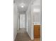 Hallway with tile floors leads to the bathroom with a wooden vanity and a bedroom at the end of the hall at 891 N Wayman St, Longwood, FL 32750