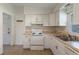 Well-lit kitchen with white cabinets and appliances, light countertops and tile flooring at 891 N Wayman St, Longwood, FL 32750