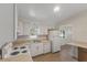 Functional kitchen with white cabinets, white appliances, light countertops, and tile flooring at 891 N Wayman St, Longwood, FL 32750