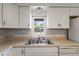 Kitchen sink with a view to the outside and white cabinets and appliances at 891 N Wayman St, Longwood, FL 32750