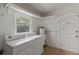 Bright laundry area featuring essential appliances and built-in shelving for organized storage solutions at 891 N Wayman St, Longwood, FL 32750