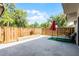 Fenced backyard with gray patio and landscaped area at 917 Royal Oak Blvd, Leesburg, FL 34748
