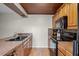Charming kitchen features wood-toned cabinetry and modern black appliances at 917 Royal Oak Blvd, Leesburg, FL 34748
