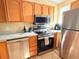 Updated kitchen features stainless steel appliances, granite counters, and stylish wood-look flooring at 963 Stucki Ter, Winter Garden, FL 34787