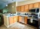 Modern kitchen boasts stainless steel appliances, granite countertops, and wooden cabinets at 963 Stucki Ter, Winter Garden, FL 34787