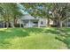 Spacious backyard with lush green grass, trees, and a covered patio at 10097 Lake District Ln, Orlando, FL 32832