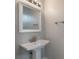 Bathroom with sleek pedestal sink and modern mirror at 10097 Lake District Ln, Orlando, FL 32832