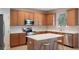 Modern kitchen with stainless steel appliances, granite countertops, island, and wooden cabinetry at 10097 Lake District Ln, Orlando, FL 32832