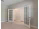 Open carpeted office space featuring double doors to hall and closets at 10097 Lake District Ln, Orlando, FL 32832