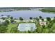 Aerial view of tennis courts next to the lake and a nearby playground in a residential area at 10097 Lake District Ln, Orlando, FL 32832