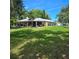 Expansive backyard with lush lawn, mature trees and a white home exterior at 1010 Bolton Rd, New Smyrna Beach, FL 32168