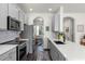 Modern kitchen with stainless steel appliances, gray cabinets, and a view into the dining area at 10255 Hartford Maroon Rd, Orlando, FL 32827