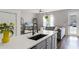 Open kitchen with white countertops, gray cabinets, and a breakfast bar overlooking the living area at 10255 Hartford Maroon Rd, Orlando, FL 32827