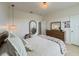 Bright bedroom with a bed, wooden dresser, and round mirror at 11091 Bagley Aly, Windermere, FL 34786