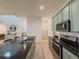 Kitchen featuring light blue cabinets, stainless steel appliances, a black countertop, and an island at 11091 Bagley Aly, Windermere, FL 34786