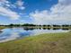 Scenic view of the community pond with calm, reflective water under a bright blue sky with fluffy clouds at 11091 Bagley Aly, Windermere, FL 34786