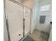 The shower features a glass door, white tiles, and a built-in shelf for added convenience at 11091 Bagley Aly, Windermere, FL 34786