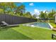 Spacious backyard featuring a pristine pool, lush green turf, and a dark privacy fence at 1127 W Harvard St, Orlando, FL 32804