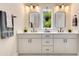 Bright bathroom featuring double sinks, white cabinets, black hardware, and a window with a view at 1127 W Harvard St, Orlando, FL 32804