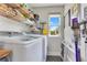 Well-organized laundry room with modern washer and dryer, storage shelves, and gray hexagon tile floor at 1127 W Harvard St, Orlando, FL 32804