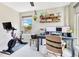 Well-lit home office with a stationary bike, dual monitors, and a view of the outdoors at 1127 W Harvard St, Orlando, FL 32804