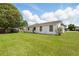 Large backyard featuring green grass, a white house and a trailer at 114 Floral Dr, Kissimmee, FL 34743