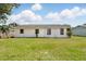 White home exterior surrounded by green lawn and blue skies at 114 Floral Dr, Kissimmee, FL 34743