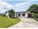 Charming single-story home with white exterior, dark shutters, and a spacious front yard at 114 Floral Dr, Kissimmee, FL 34743