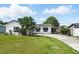 Charming single-story home with white exterior, dark shutters, and a spacious front yard at 114 Floral Dr, Kissimmee, FL 34743
