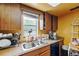 Kitchen area with stainless steel sink, wood cabinets, and a window view at 114 Floral Dr, Kissimmee, FL 34743