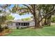 Green backyard featuring mature trees, a screened porch and a grassy area providing a serene outdoor space at 1204 Howell Creek Dr, Winter Springs, FL 32708
