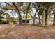 Backyard view showcasing the home's exterior, mature trees, and well-maintained landscaping at 1204 Howell Creek Dr, Winter Springs, FL 32708