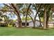A home nestled among mature trees, with a well-maintained lawn and a glimpse of a wooden fence at 1204 Howell Creek Dr, Winter Springs, FL 32708