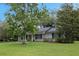 Charming single-story home featuring a welcoming front lawn, painted brick, and yellow front door at 1204 Howell Creek Dr, Winter Springs, FL 32708