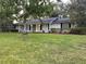 Charming single-story home featuring a bright yellow door, black shutters, and well-maintained front yard at 1204 Howell Creek Dr, Winter Springs, FL 32708