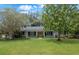 Charming single-story home featuring a manicured lawn, mature trees, and a welcoming yellow front door at 1204 Howell Creek Dr, Winter Springs, FL 32708
