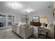 Bright living room with neutral walls, plush seating, and double doors to the backyard at 1204 Howell Creek Dr, Winter Springs, FL 32708