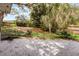 Large concrete patio leading to a grassy backyard, surrounded by mature trees and wooden fence at 1204 Howell Creek Dr, Winter Springs, FL 32708