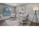 Inviting sitting room with two armchairs, decorative rug, accent cabinet, and a modern floor lamp at 1204 Howell Creek Dr, Winter Springs, FL 32708