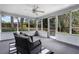 Relaxing screened porch with two wicker chairs, views of the private backyard, and access to the outdoors at 1204 Howell Creek Dr, Winter Springs, FL 32708