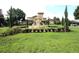 Clubhouse with a lush lawn, a prominent fountain, and views of the parking lot at 122 Vista Verdi Cir # 236, Lake Mary, FL 32746