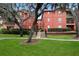 Beautiful red brick apartment building featuring mature trees and a well-maintained lawn at 122 Vista Verdi Cir # 236, Lake Mary, FL 32746