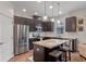 Stylish kitchen with a center island, stainless steel appliances, and sleek dark cabinetry at 13993 Tarvin St, Orlando, FL 32832