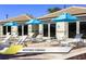 Rentable cabanas with lounge chairs and blue umbrellas by the pool at 1466 Moon Valley Dr, Champions Gate, FL 33896