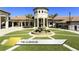 Clubhouse featuring a fountain, lush landscaping, and sidewalks at 1466 Moon Valley Dr, Champions Gate, FL 33896