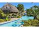 Enjoy the inviting lazy river with colorful inner tubes, a tiki hut, and lush tropical landscaping at 1466 Moon Valley Dr, Champions Gate, FL 33896